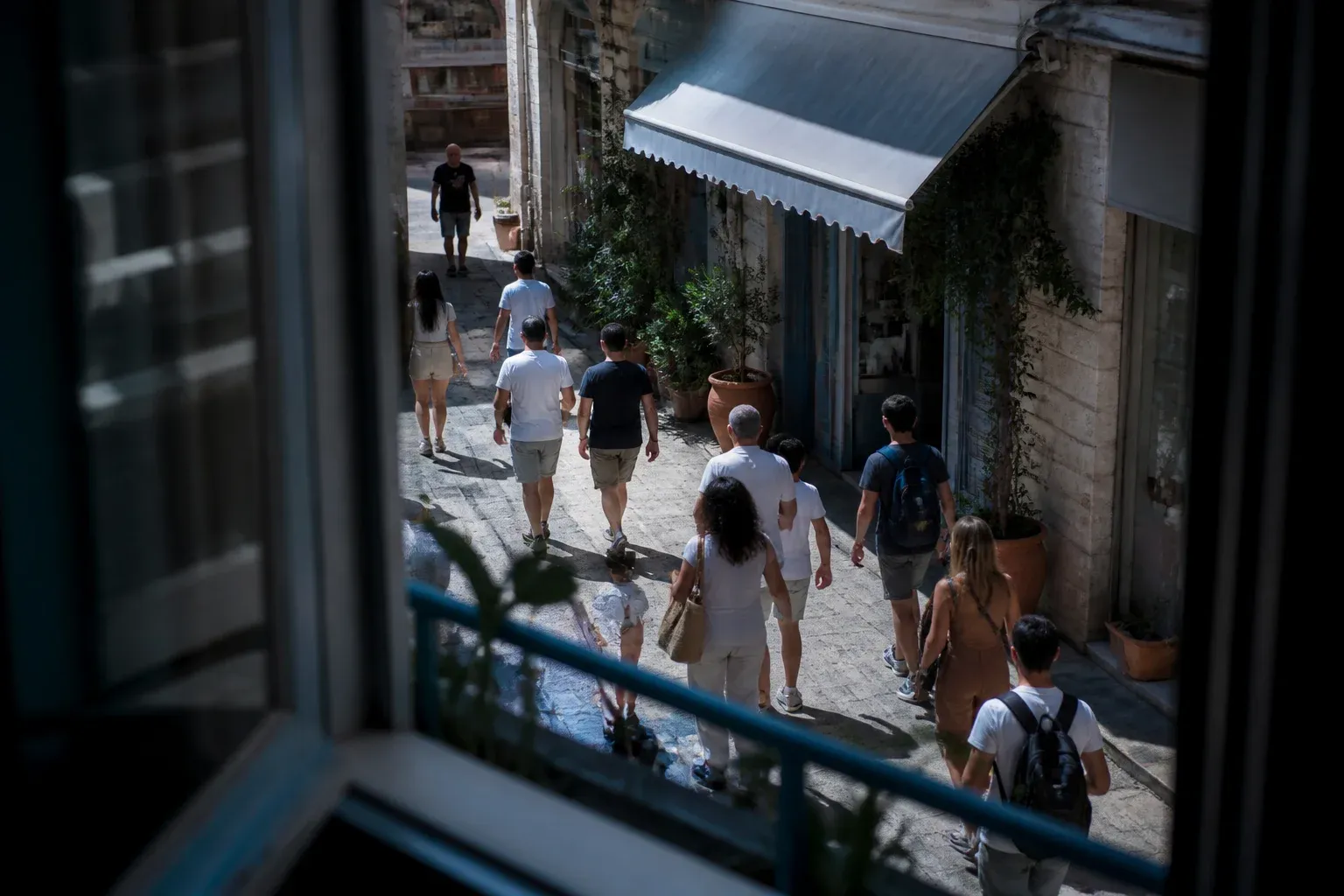 רחוב הולכי רגל מחלון בקומה ראשונה והולכים לעבר חנות פינתית